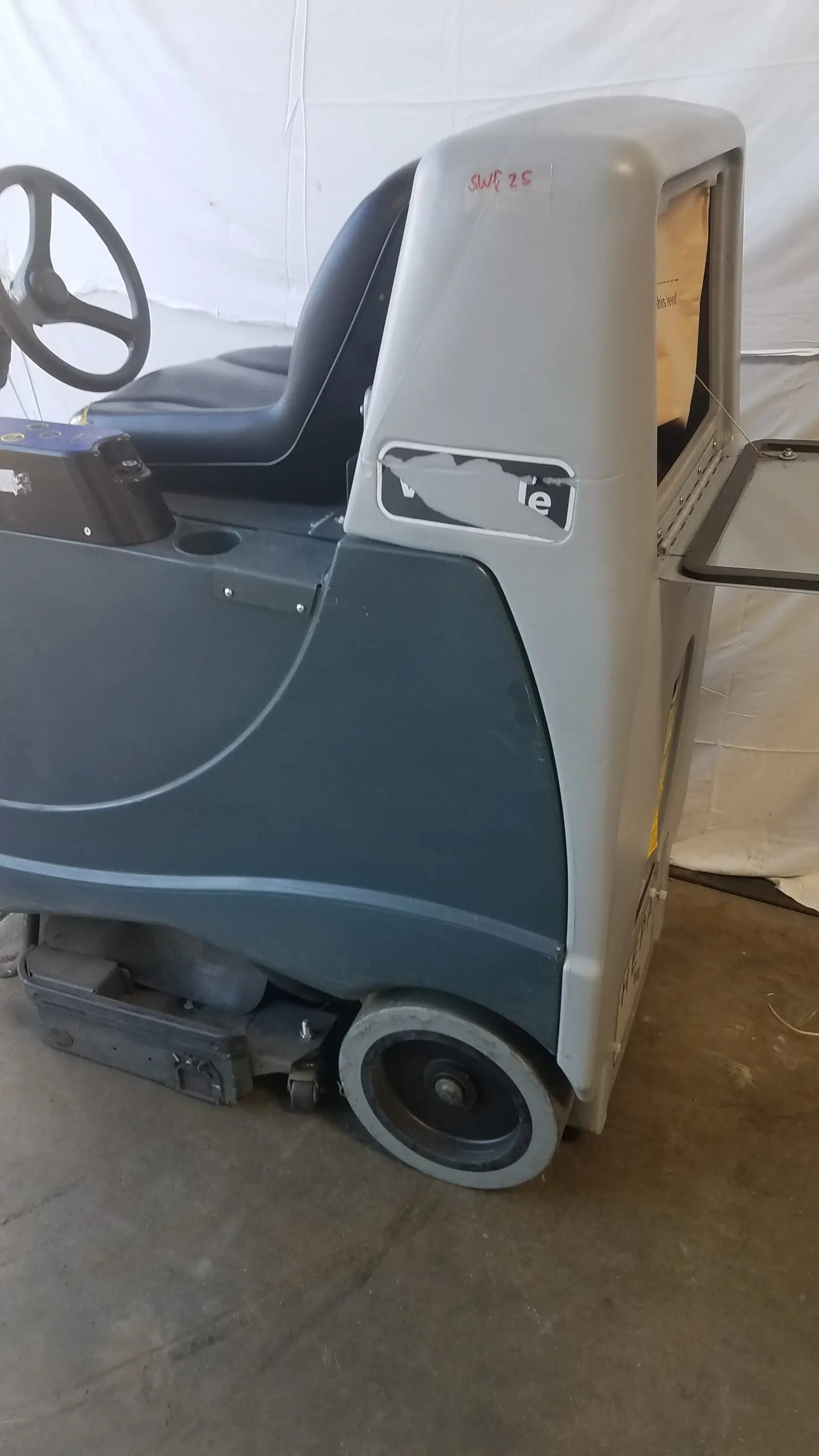 Advance ride on carpet cleaner extractor wet dry vacuum in gray and black with steering wheel and visible cleaning mechanism