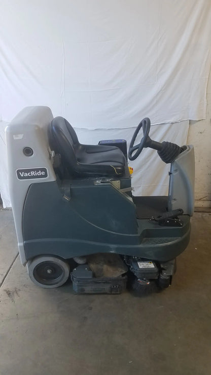Gray and black Advance Ride On carpet cleaner extractor with driver seat steering wheel and front scrubbing brushes
