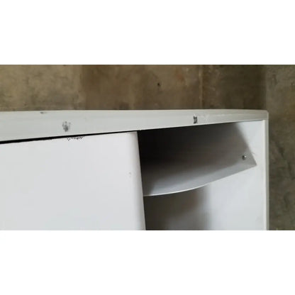 White metal cabinet with sliding door partially open revealing an interior shelf of advanced sterilization products sterrad nx sterilizer