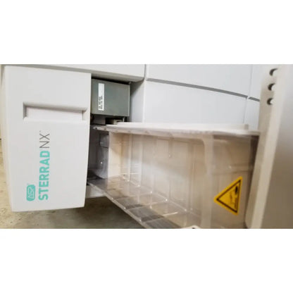 White sterrad nx sterilizer with transparent tray and yellow warning label by advanced sterilization products