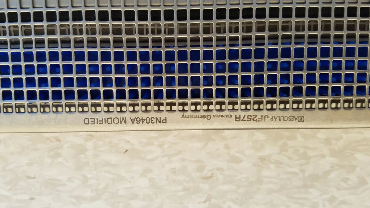 Metallic blue tinted perforated panel with square holes engraved with f on aesculap jf257r sterilization case tray pn2089a modified