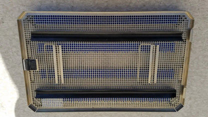 Rectangular metal mesh heater with gold-toned frame black heating elements and blue insulation panels in aesculap jf257r sterilization case tray