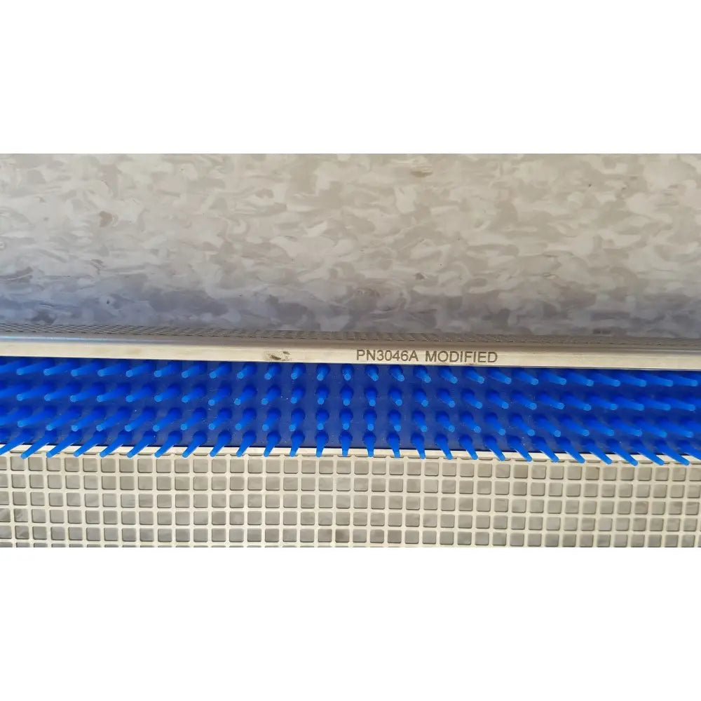 Blue plastic comb-like component with white metallic frame marked pn3046a modified for aesculap jf257r sterilization case tray
