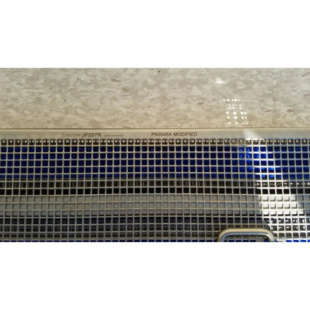 Stainless steel ventilation grille with engraved model markings on the back of aesculap jf257r sterilization case tray