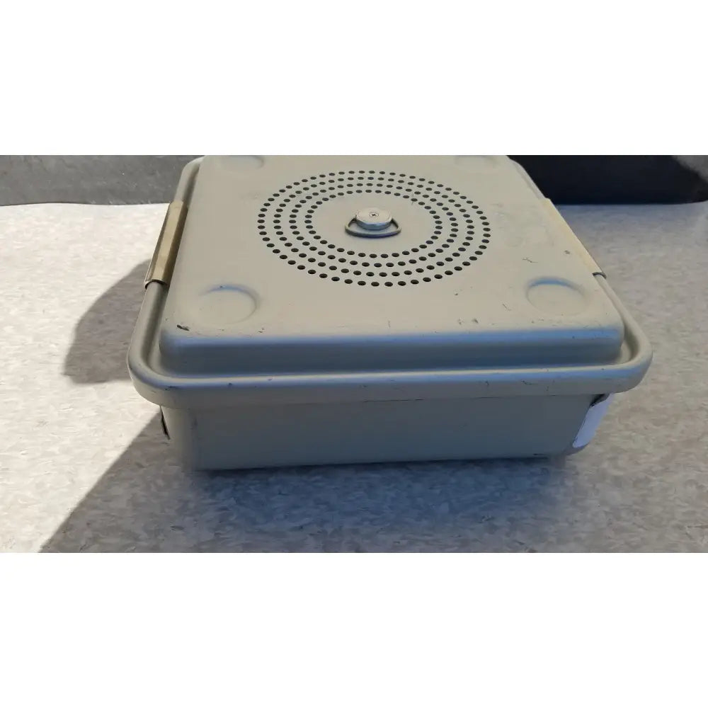 Beige plastic aesculap jk341 half size sterilization case lid with hinged lid and circular perforation pattern