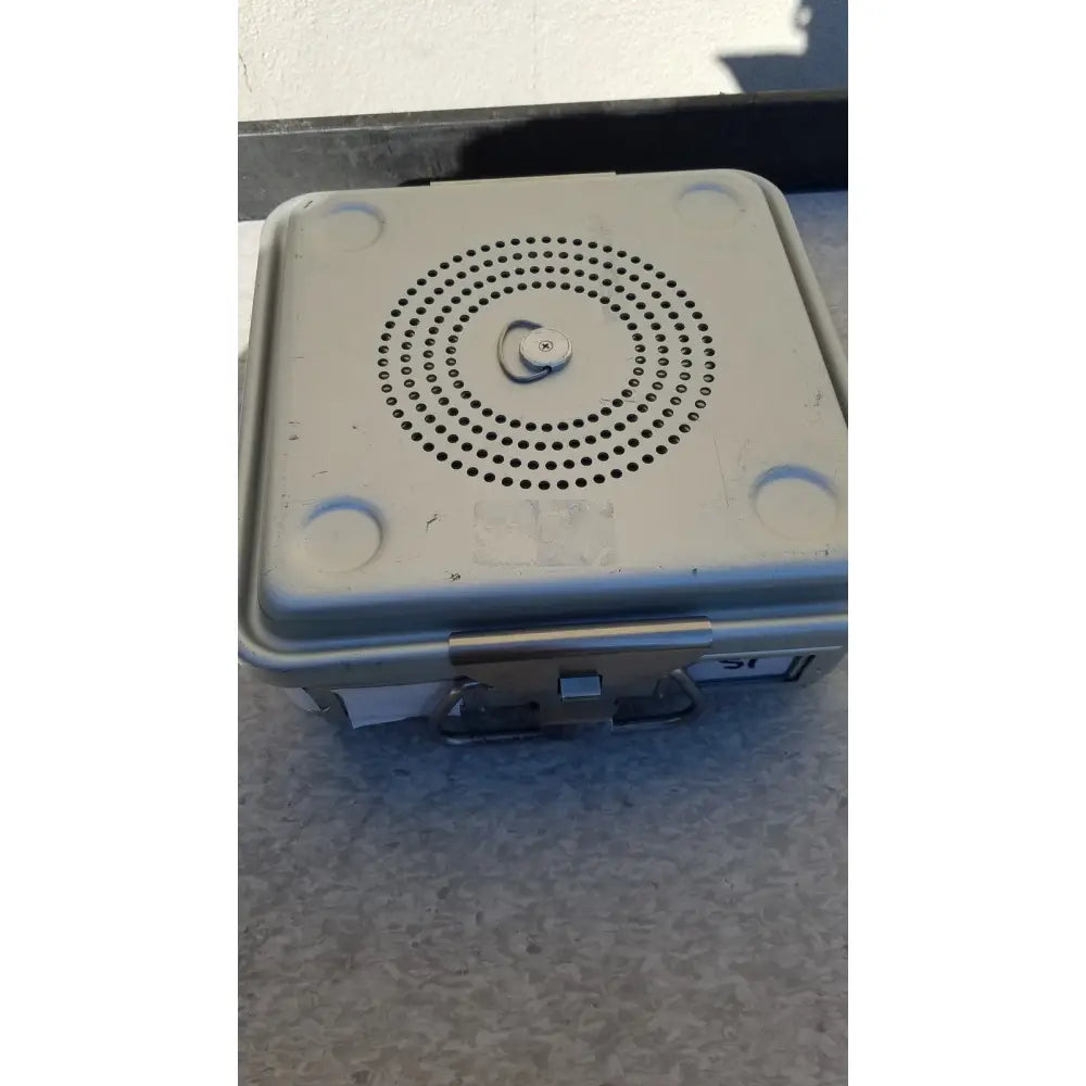 Light gray plastic aesculap jk341 half size sterilization case with circular perforations and central latch