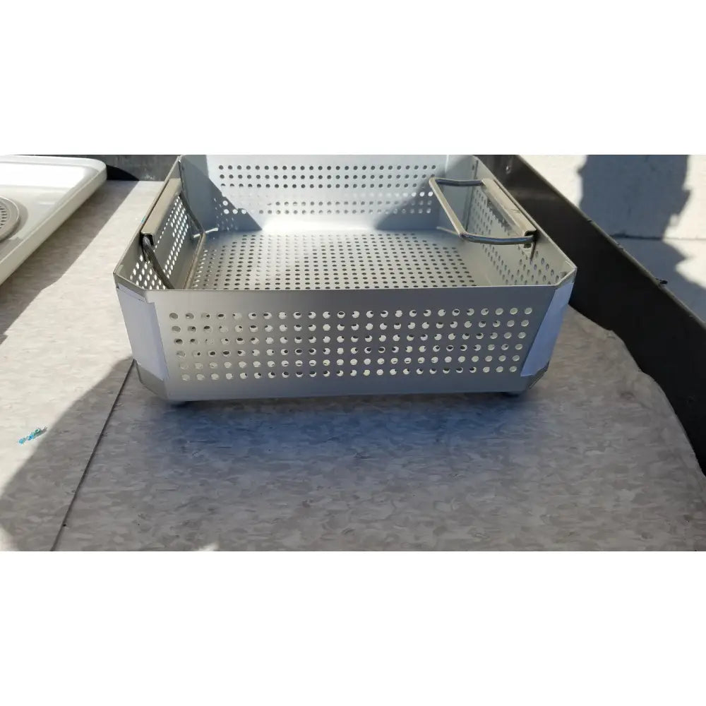 Silver perforated metal baking pan with reinforced corners and handle for aesculap jk341 half size sterilization case