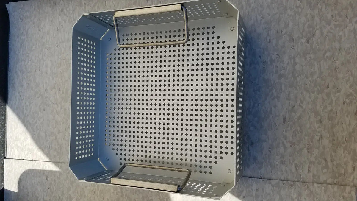 Silver perforated metal grill basket with handle and base tray in aesculap jk341 half size sterilization case