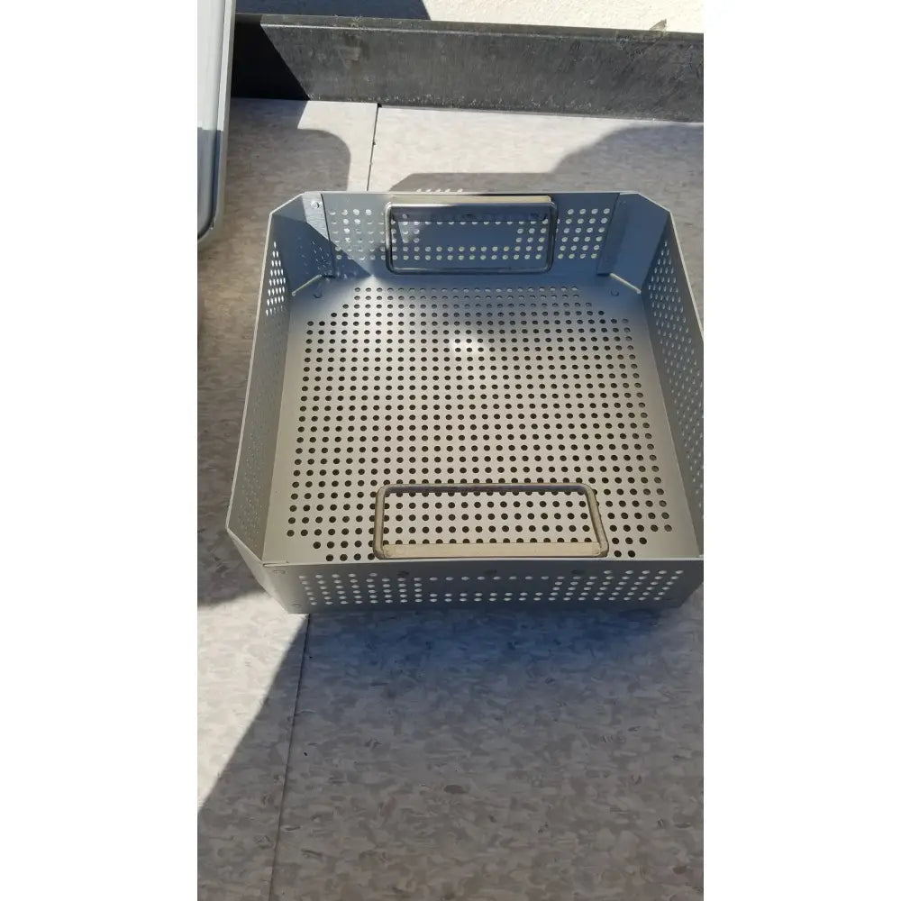 Gray perforated metal basket with two rectangular handle cutouts for aesculap jk341 half size sterilization case