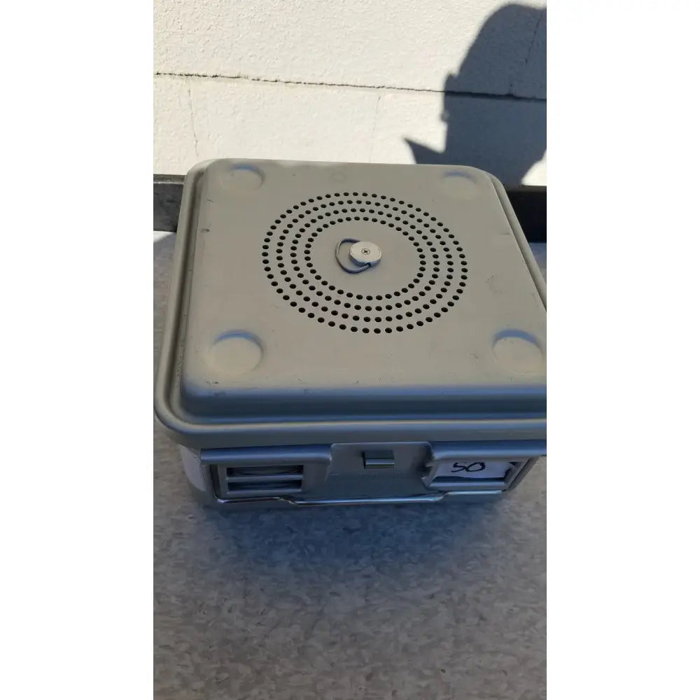 Gray plastic aesculap jk341 half size sterilization case lid with circular perforations and central knob