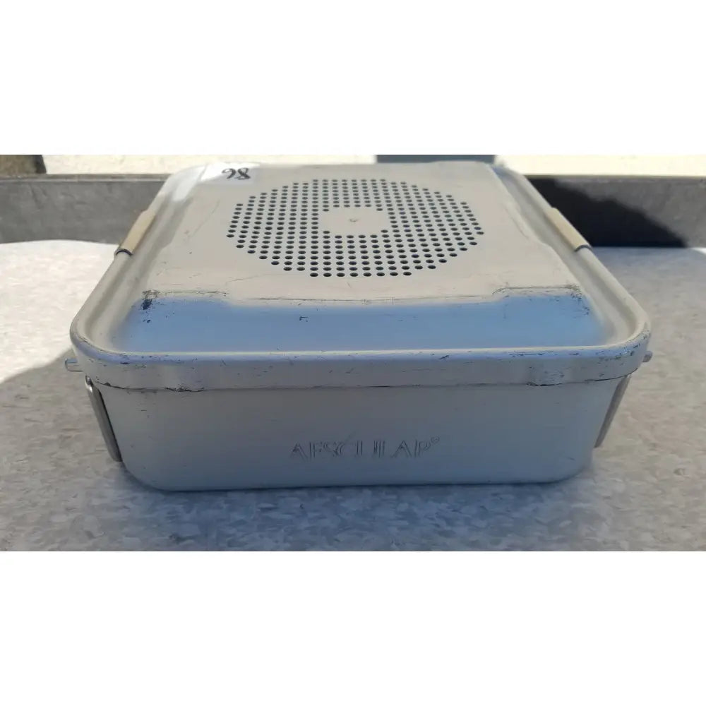 A weathered light gray metal aesculap jn340 instrument sterilization container with perforated lid embossed afzuhar
