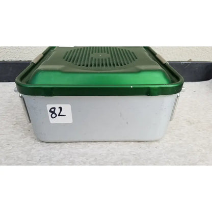Green and gray plastic aesculap jn341 sterilization container with perforated lid for secure medical instrument storage