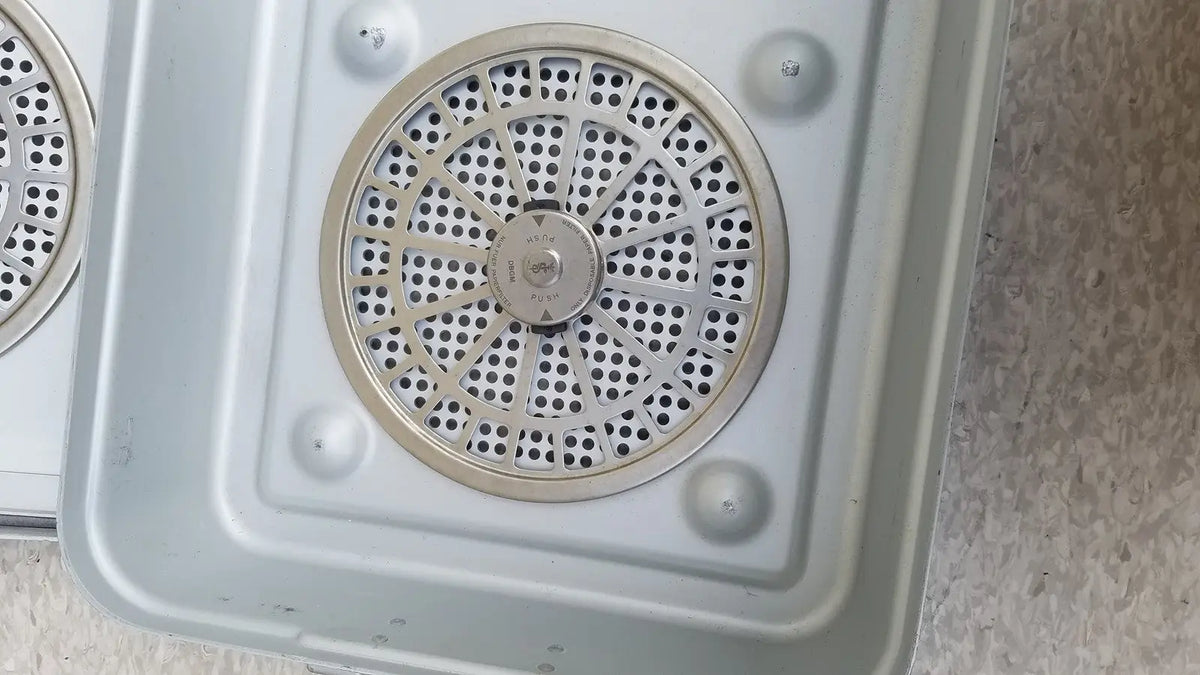 Silver circular vent with perforated metal grille and central control knob on aesculap jn821 sterilization case instrument tray