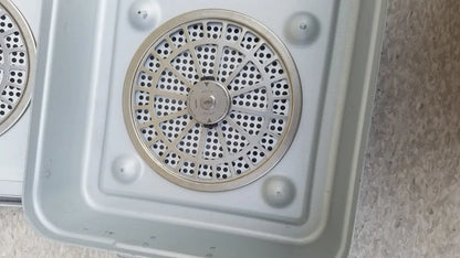 Silver circular vent with perforated metal grille and central control knob on aesculap jn821 sterilization case instrument tray