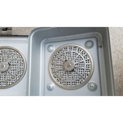 Silver metallic circular perforated grates set into a metal tray of the aesculap jn821 sterilization case instrument tray