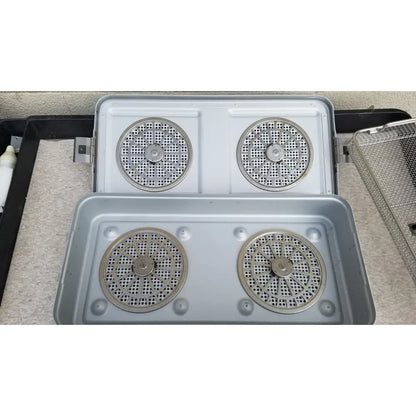 Silver-colored metal aesculap jn821 sterilization case instrument tray with four circular perforated heating elements in 2x2 grid