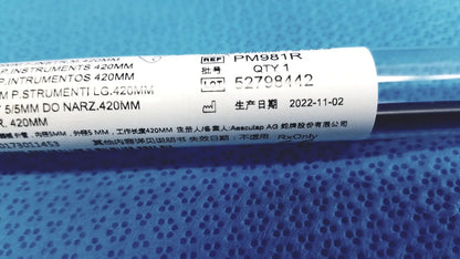 A black cylindrical aesculap laparoscopic grasper ref pm981r with a white label showing product details and brand name