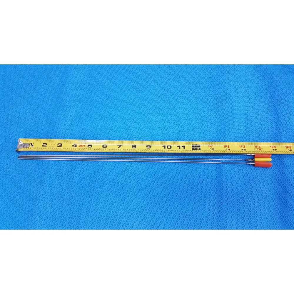 Three slender metallic aesculap laparoscopic instrument needles with orange and yellow handles and measuring tape for reuse medical use