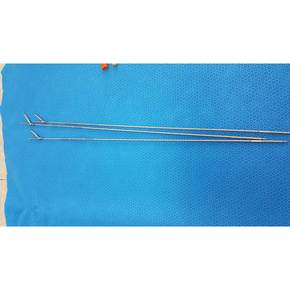 Two slender metallic aesculap laparoscopic instrument forceps with articulated tips on blue textured surface reuse medical