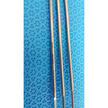 Three metallic aesculap laparoscopic instrument drill bits with engraved markings on a blue perforated surface