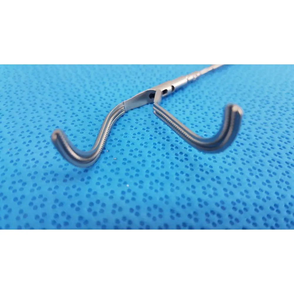 Silver surgical forceps with curved serrated jaws and textured handle from aesculap laparoscopic instrument model pm 716r