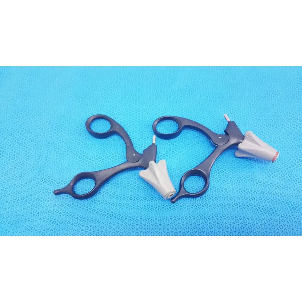 Black Aesculap p0958r quick snap non-ratchet laparoscopic scissors with white cone-shaped tips on blue surface
