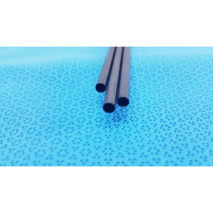 Three black pm973r insulated outer tubes 5 x 310 mm lie parallel on a perforated blue surface by aesculap