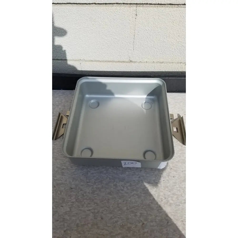 Silver rectangular metal aesculap sterilization container with rounded corners and four circular indentations without lid