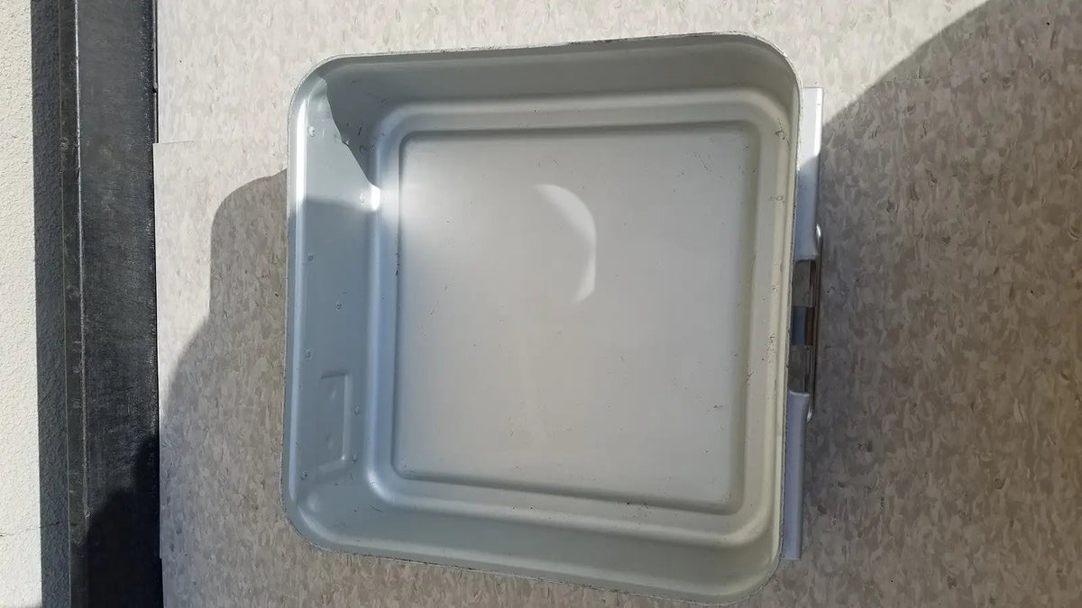 Gray metal aesculap sterilization container without lid featuring a square raised lid and visible side hinges