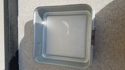 Gray metal aesculap sterilization container without lid featuring a square raised lid and visible side hinges