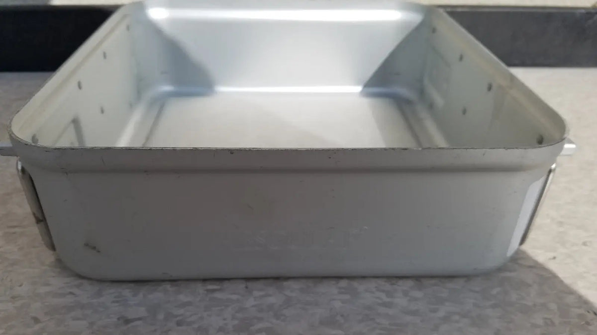 Silver-colored rectangular metal aesculap sterilization container without lid with riveted edges and slightly worn finish