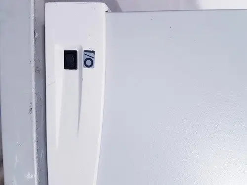 White refrigerator door with black power switch and circular sticker on affymetrix genechip fluidics station 450