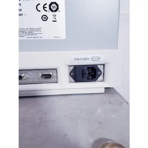 White plastic power input port with black plug and metal connector plate on the back of affymetrix genechip fluidics station 450