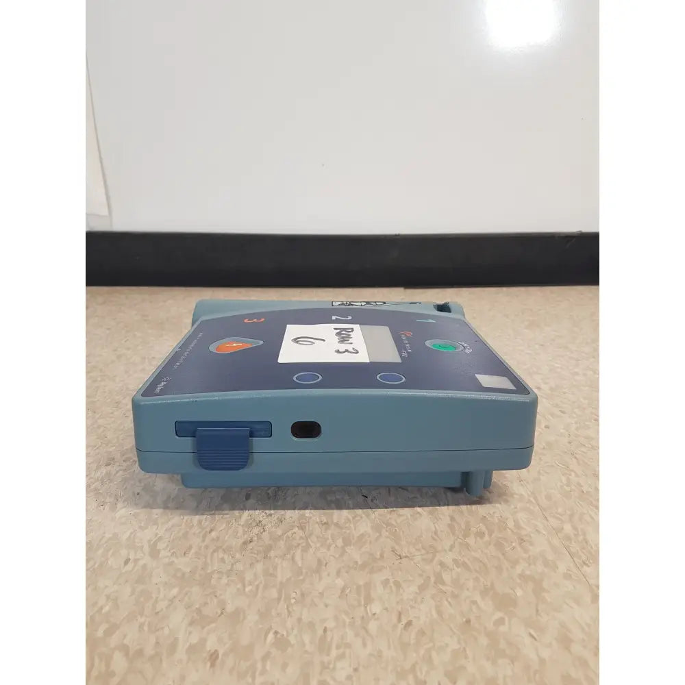 Blue portable agilent heartstream fr2 semi automatic defibrillator with digital display and control buttons for emergencies