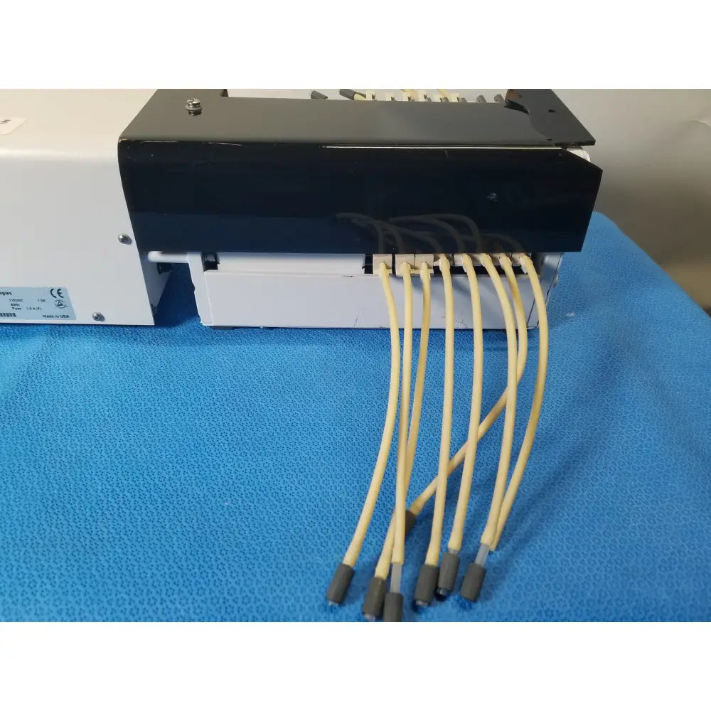 Black and white Agilent Technologies 810 peristaltic pump with six beige tubing connectors for reuse medical applications