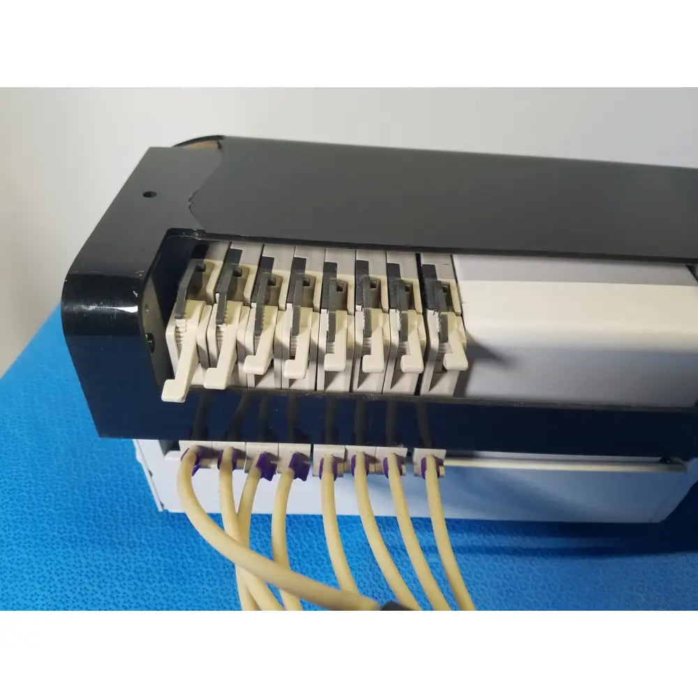 Black plastic electrical switch panel with beige and gray toggle switches and yellow cables on agilent technologies 810 peristaltic pump