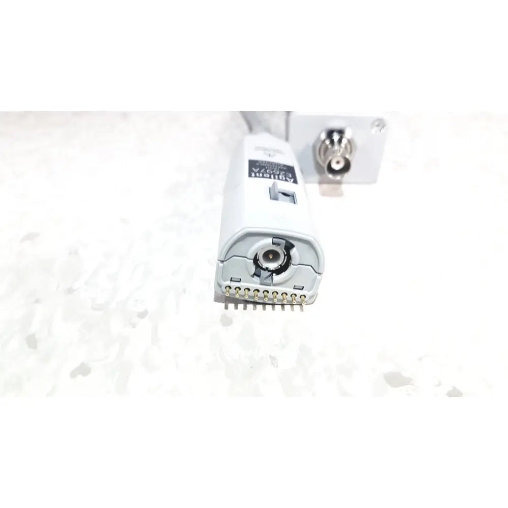 White plastic agilent technologies e2697a high impedance adapter with metallic pins and circular port labeled adapti