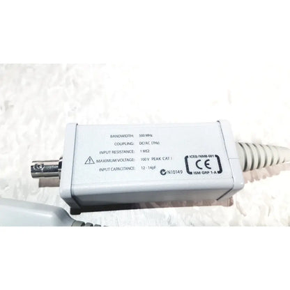 White rectangular electronic signal coupling unit with silver BNC connector and coiled cable agilent technologies e2697a high impedance adapter