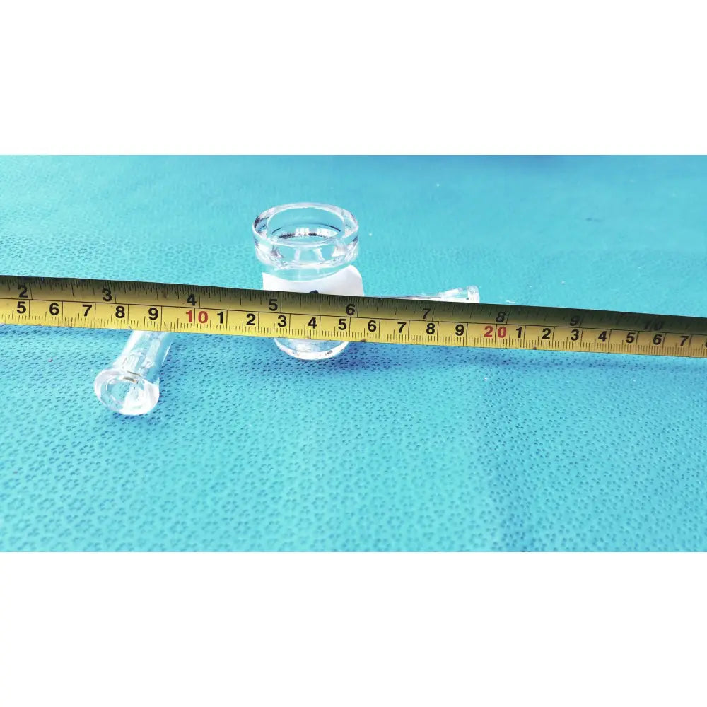Clear glass airfree flushing adapter with cylindrical body and threaded neck beside measuring tape on blue surface for schlenk line glassware lab