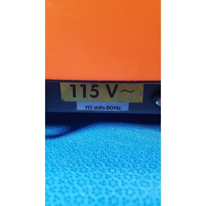 Orange alcatel drytel vacuum pump station with yellow 115 v label and white 115 volts sticker on electrical device