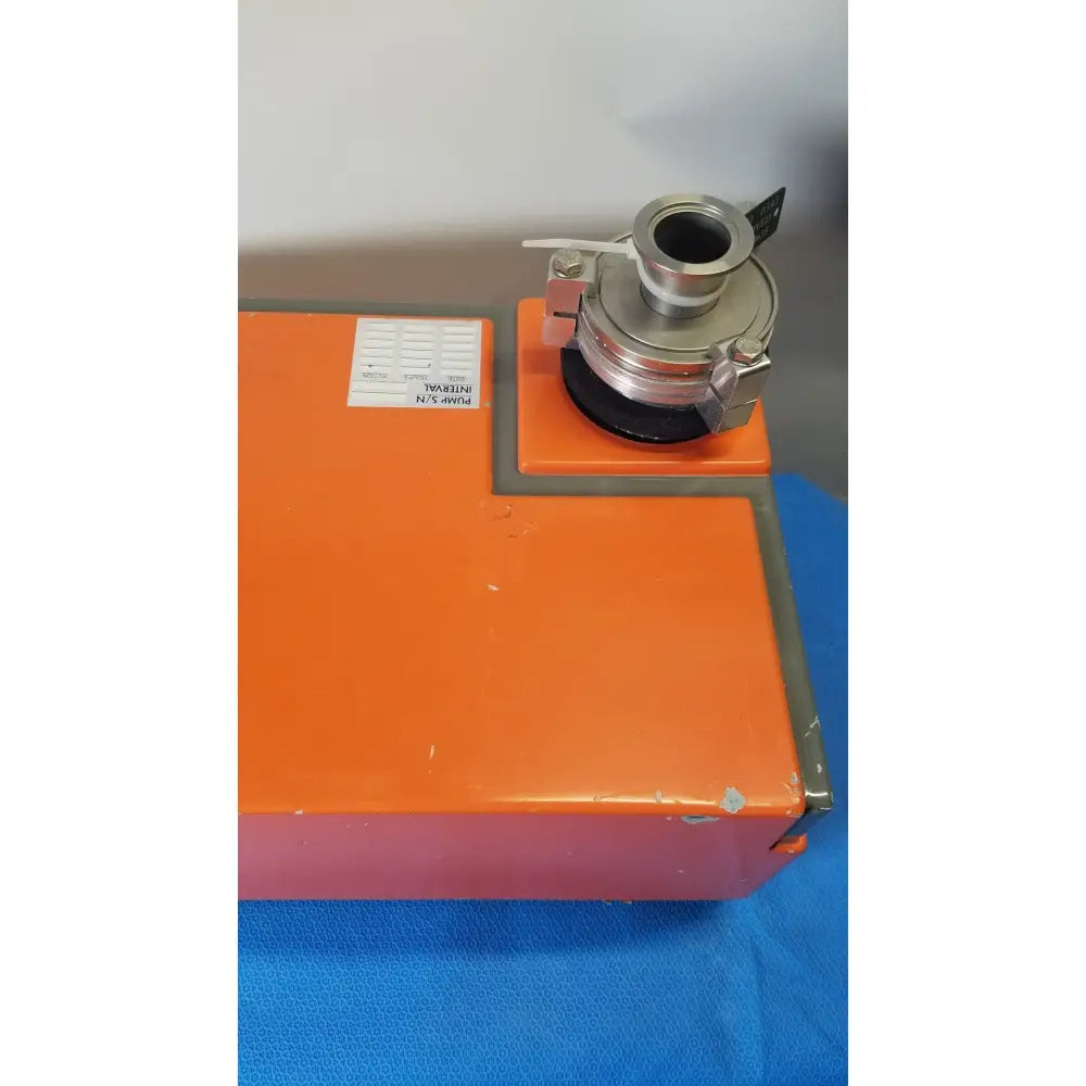 Orange rectangular metal vacuum pump station with silver mechanical coupling mounted on top by alcatel drytel