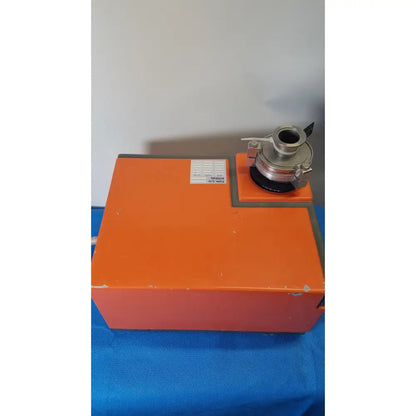 Orange industrial laser cutter with metallic cylindrical attachment on top of alcatel drytel 31 vacuum pump station