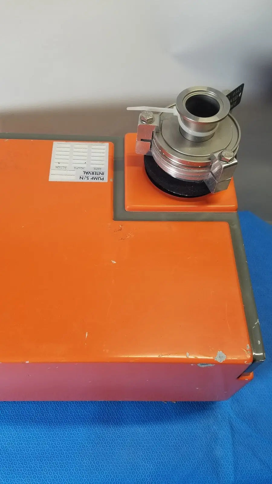Orange rectangular metal vacuum pump station with silver mechanical coupling mounted on top by alcatel drytel
