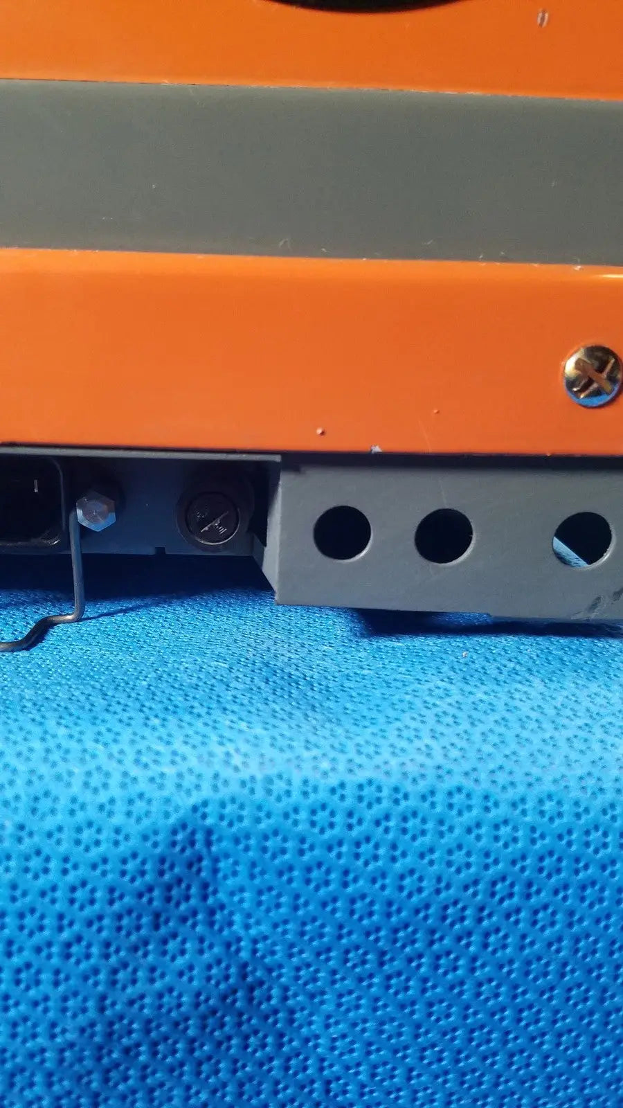 Orange and gray industrial alcatel drytel 31 vacuum pump station with metallic screw head as key feature