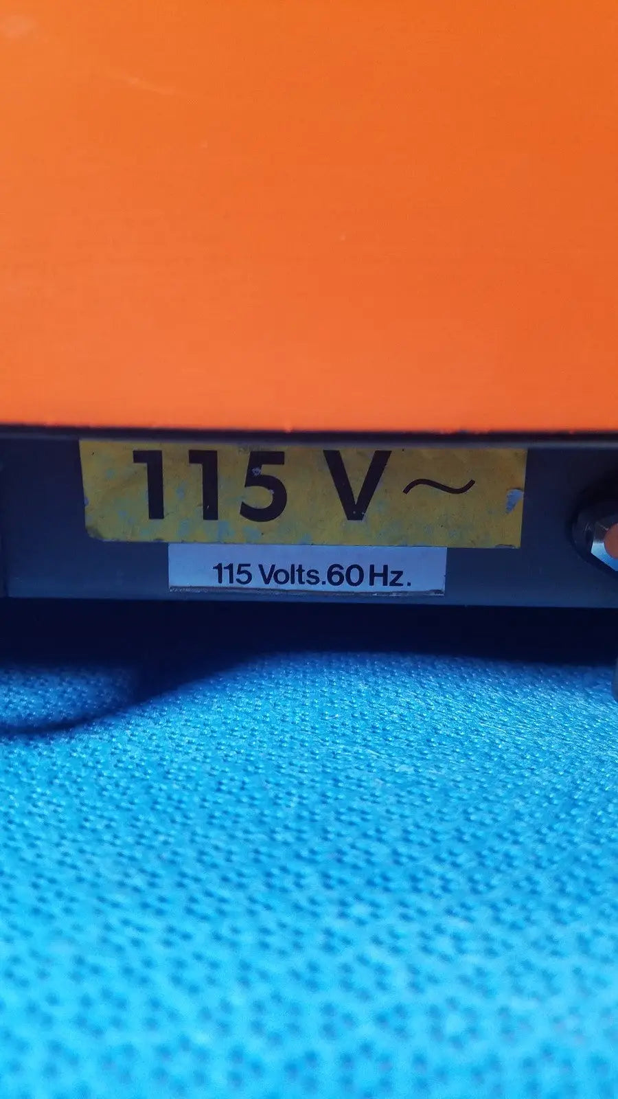Orange alcatel drytel vacuum pump station with yellow 115 v label and white 115 volts sticker on electrical device