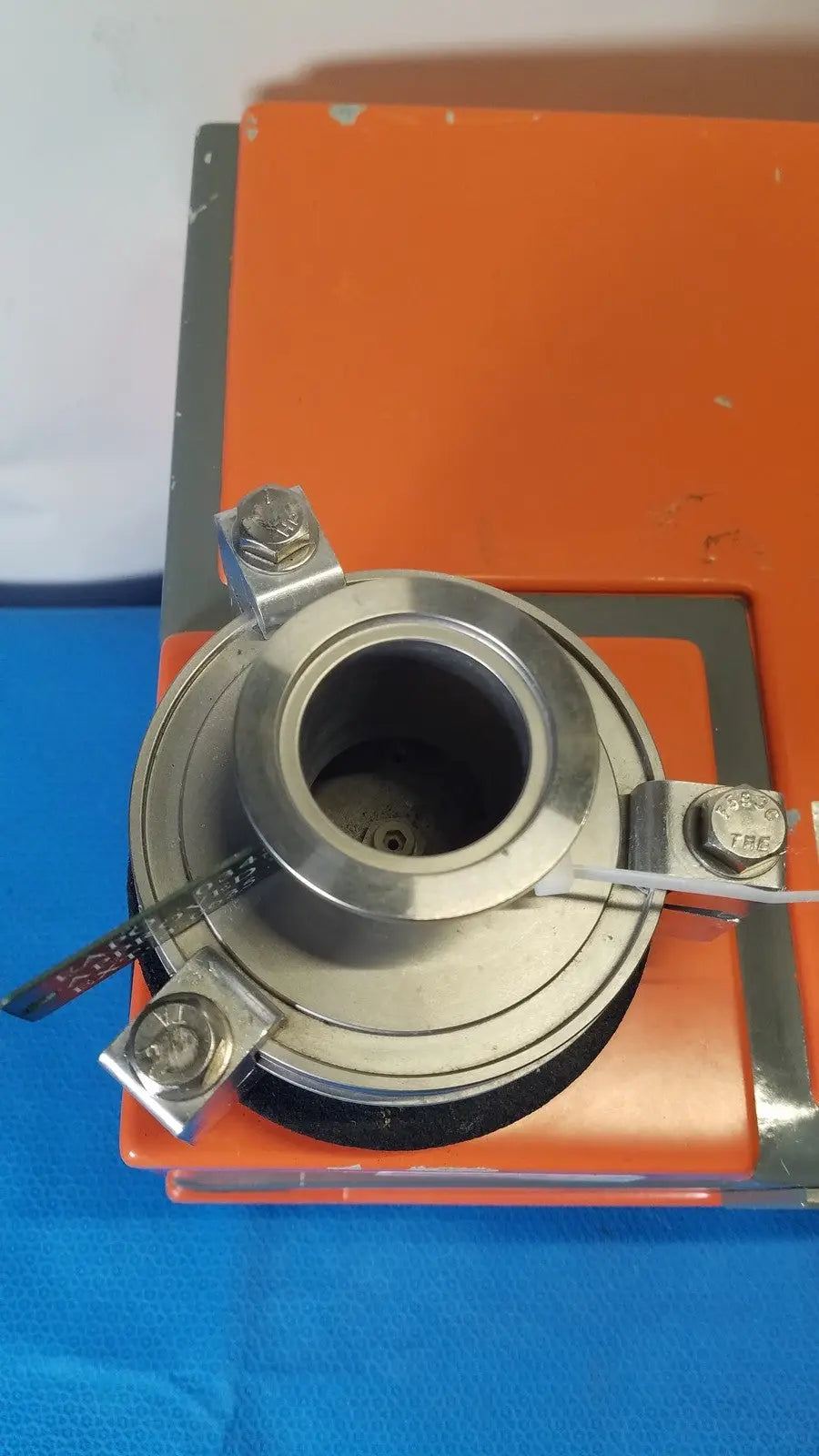 Silver metallic flange with three bolted mounting brackets and central hollow bore for alcatel drytel vacuum pump station