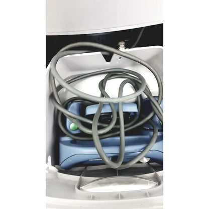 Blue plastic alcon infiniti vision phacoemulsification device with green buttons and coiled gray cables in white container