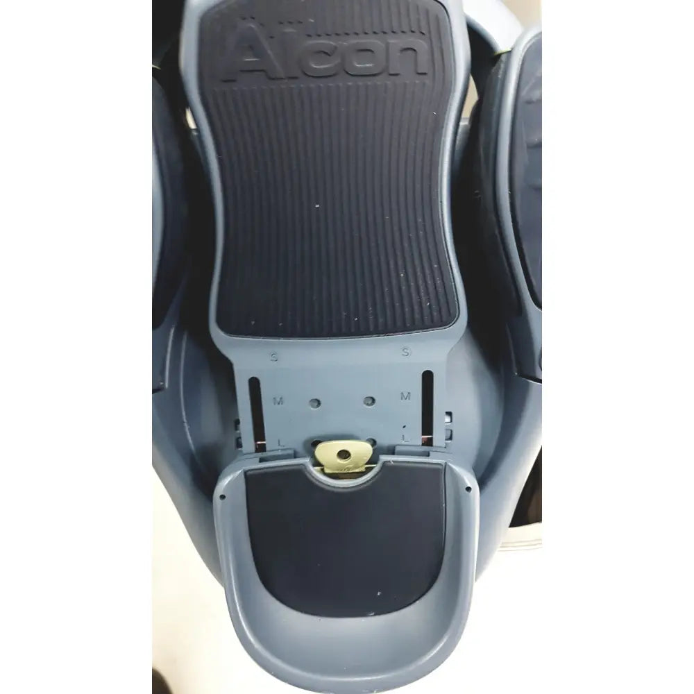 Gray Alcon Infiniti Vision system footrest with black textured rubber pads and adjustable sizing markings