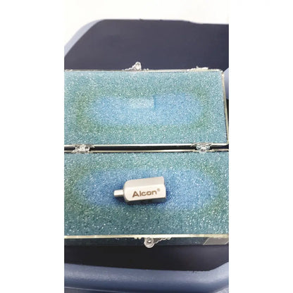 Silver alcon infiniti vision branded medical device with cylindrical body resting on blue foam inside open case
