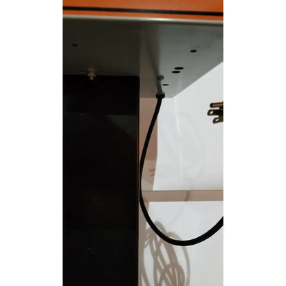 Black cable hanging from metal bracket on the back side of allied healthcare gomco 3040 aspirator device